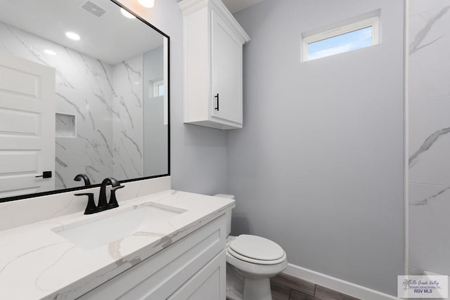 2023 Peace Dr # 23, La Feria, TX 78559 - bathroom featuring vanity, toilet, wood finished floors, and baseboards
