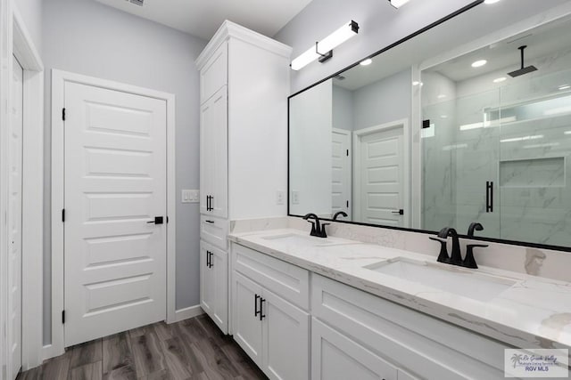 2023 Peace Dr # 23, La Feria, TX 78559 - bathroom with a marble finish shower, double vanity, wood finished floors, and baseboards