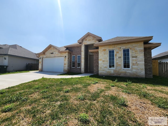 view of front of house featuring a front yard, fence, concrete driveway, stone siding, and a garage