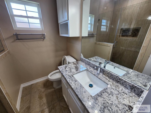 full bathroom with vanity, a shower stall, toilet, and baseboards