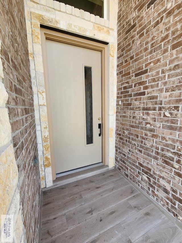 entrance to property featuring brick siding