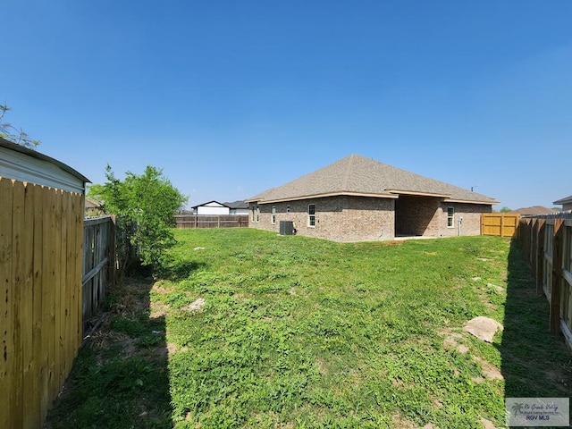 view of yard with central AC and a fenced backyard