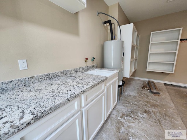 interior space with baseboards, water heater, and a sink