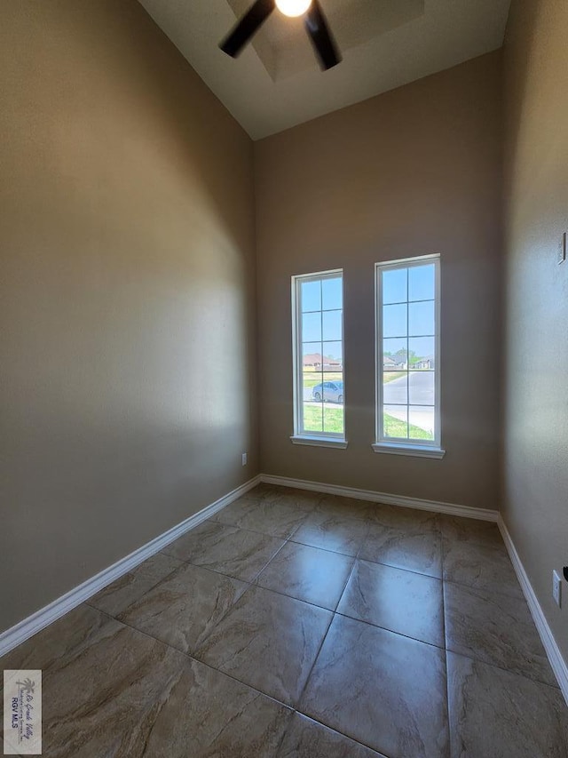 empty room featuring baseboards and ceiling fan