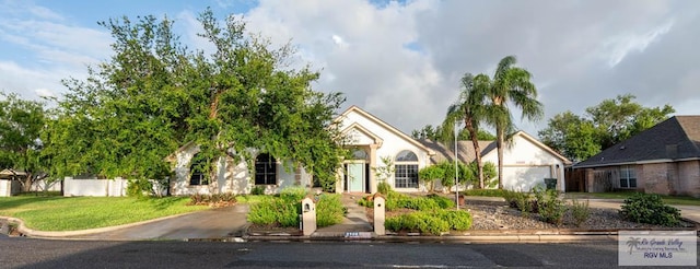 view of property hidden behind natural elements featuring a front lawn