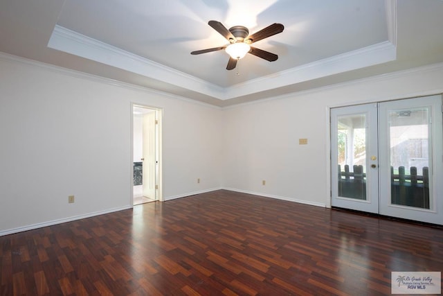 unfurnished room featuring a tray ceiling, dark hardwood / wood-style flooring, french doors, and ornamental molding