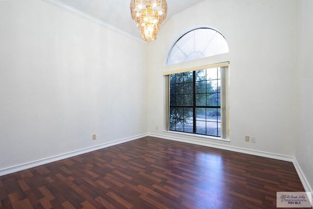 empty room featuring a chandelier, crown molding, a towering ceiling, and dark wood-type flooring