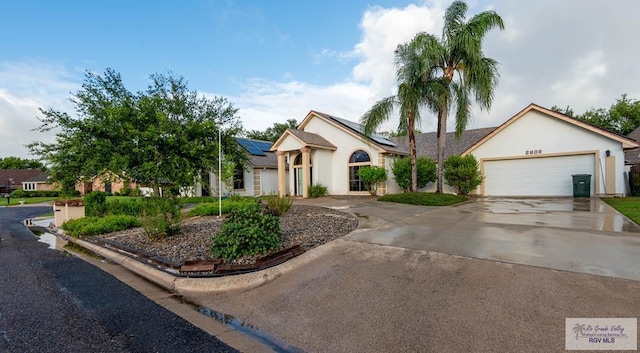 view of front of house with a garage and solar panels