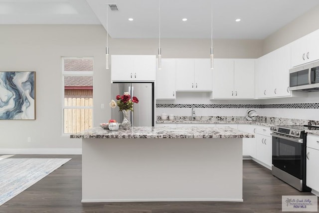 kitchen featuring light stone counters, pendant lighting, a center island, and stainless steel appliances