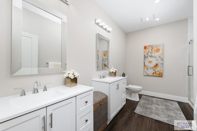 6121 Guadalupe River St, Brownsville, TX 78521 - bathroom featuring two vanities, wood finished floors, toilet, a shower stall, and baseboards