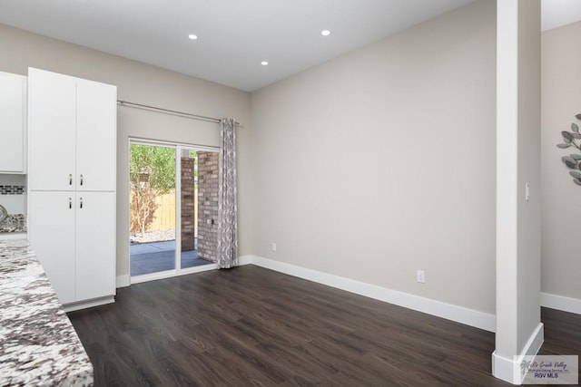 6121 Guadalupe River St, Brownsville, TX 78521 - unfurnished living room featuring dark wood-type flooring, baseboards, and recessed lighting