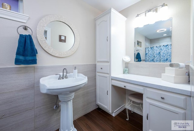 bathroom with hardwood / wood-style floors, tile walls, and walk in shower