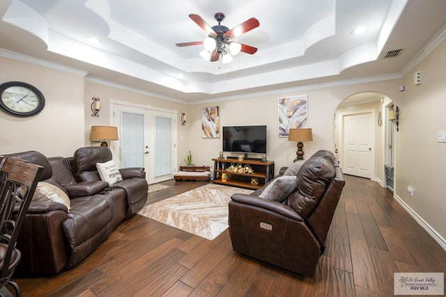 living room featuring ornamental molding, french doors, dark wood-type flooring, and a tray ceiling