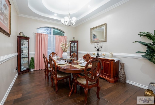 dining area with a tray ceiling, crown molding, dark hardwood / wood-style floors, and an inviting chandelier