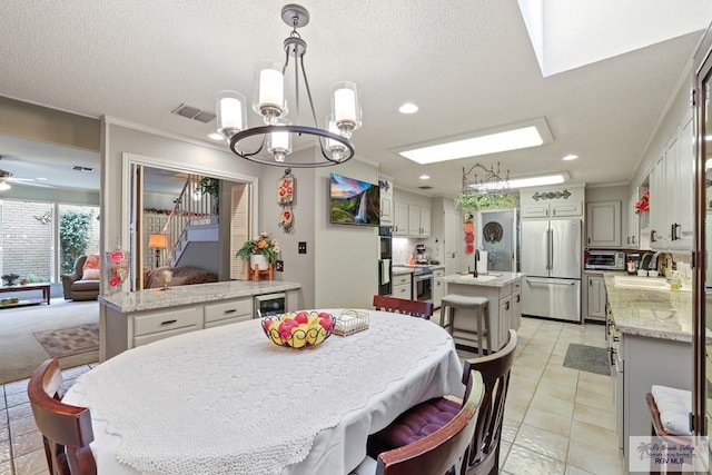 105 E Austin Ave, Harlingen, TX 78550 - dining area with a chandelier, wine cooler, light tile patterned flooring, a textured ceiling, and recessed lighting