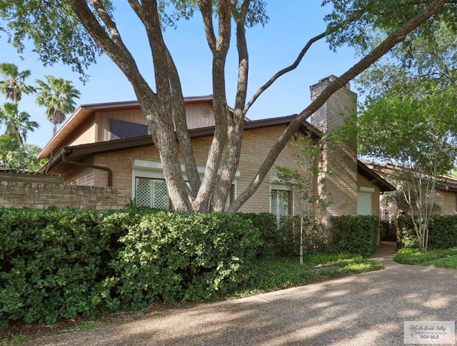 105 E Austin Ave, Harlingen, TX 78550 - view of property exterior featuring a chimney and brick siding