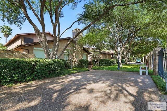 105 E Austin Ave, Harlingen, TX 78550 - view of front of home with a chimney, brick siding, and an attached garage