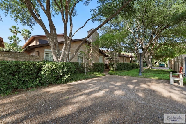 105 E Austin Ave, Harlingen, TX 78550 - view of side of home with a chimney and brick siding