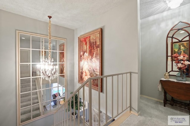105 E Austin Ave, Harlingen, TX 78550 - hall featuring an upstairs landing, a chandelier, a textured ceiling, carpet flooring, and baseboards