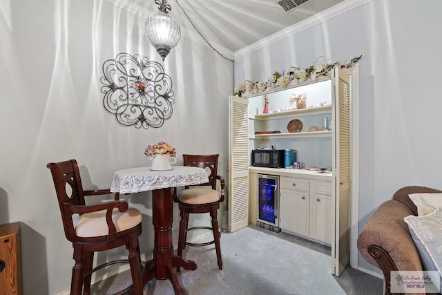 105 E Austin Ave, Harlingen, TX 78550 - dining room featuring beverage cooler, ornamental molding, light colored carpet, and a dry bar