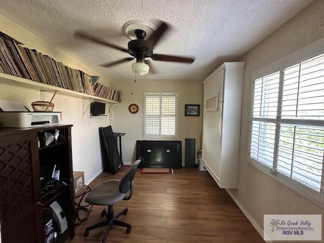 office area featuring hardwood / wood-style floors, ceiling fan, a healthy amount of sunlight, and a textured ceiling