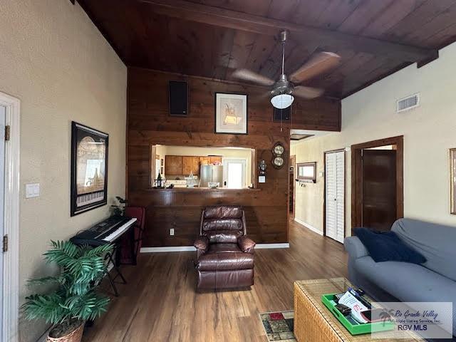 living room featuring vaulted ceiling with beams, ceiling fan, dark hardwood / wood-style flooring, and wood ceiling