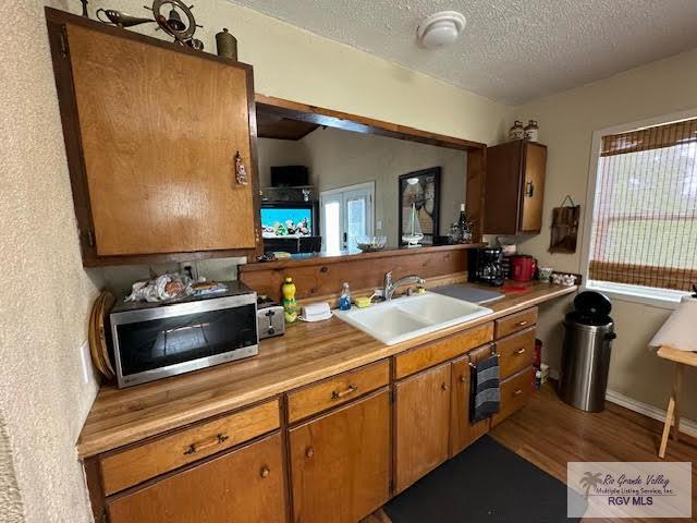 kitchen with sink, wood-type flooring, and a textured ceiling