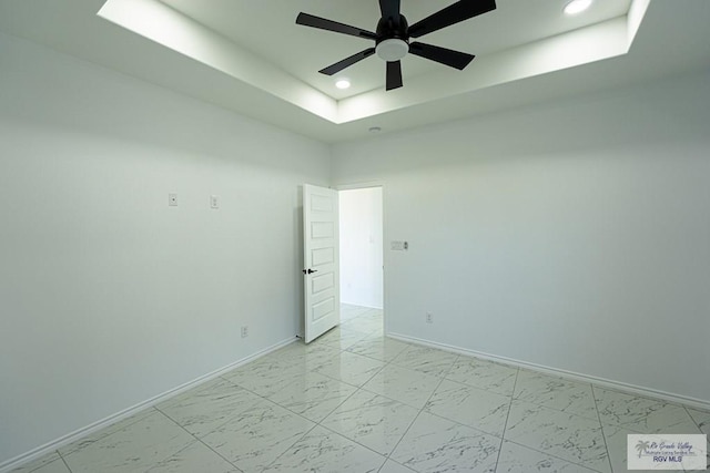 unfurnished room with a raised ceiling and ceiling fan