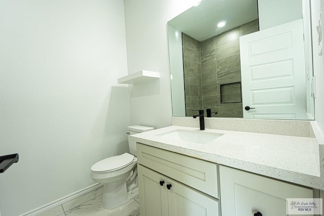 bathroom with vanity, toilet, and a tile shower