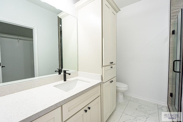 bathroom with a shower with door, vanity, and toilet