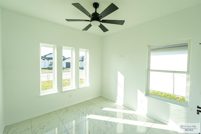 empty room featuring a wealth of natural light and ceiling fan