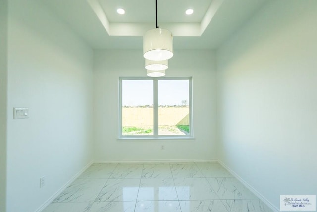 unfurnished room featuring a tray ceiling