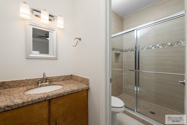 bathroom featuring an enclosed shower, vanity, and toilet