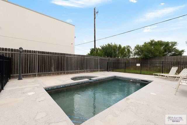 view of pool featuring an in ground hot tub and a patio