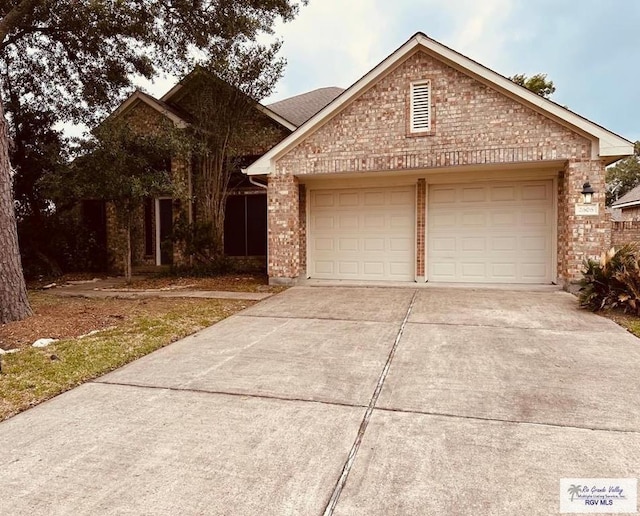 view of front of house featuring concrete driveway, an attached garage, and brick siding