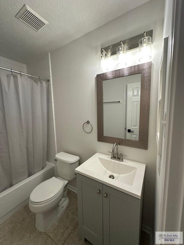 full bathroom featuring toilet, vanity, a textured ceiling, shower / bathtub combination with curtain, and tile patterned flooring