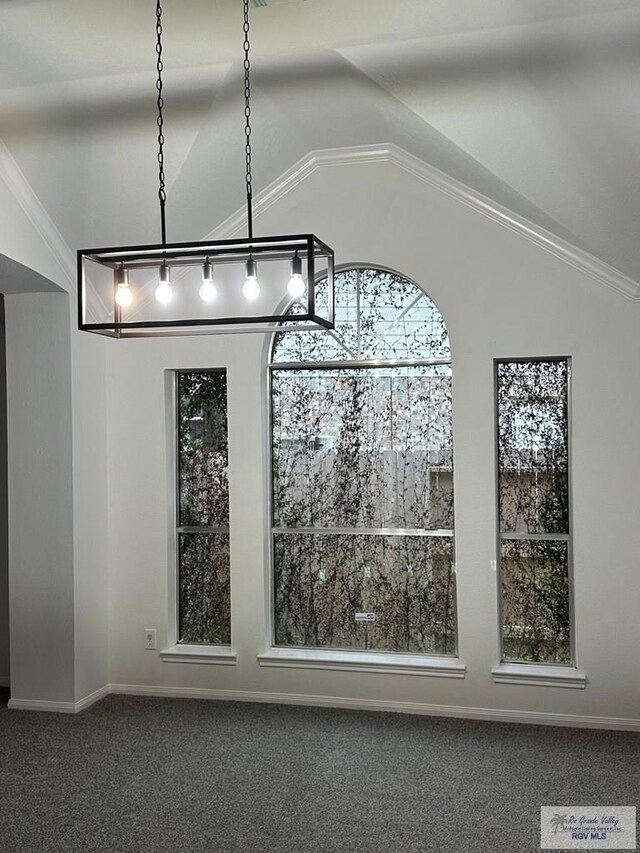 unfurnished dining area featuring carpet flooring, vaulted ceiling, baseboards, and crown molding