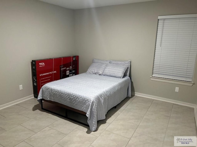 bedroom featuring baseboards and tile patterned floors