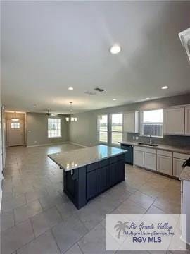 kitchen with recessed lighting, a center island, dishwasher, open floor plan, and light countertops