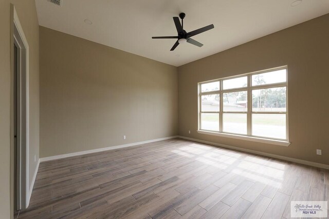 unfurnished room with hardwood / wood-style flooring, ceiling fan, and a healthy amount of sunlight