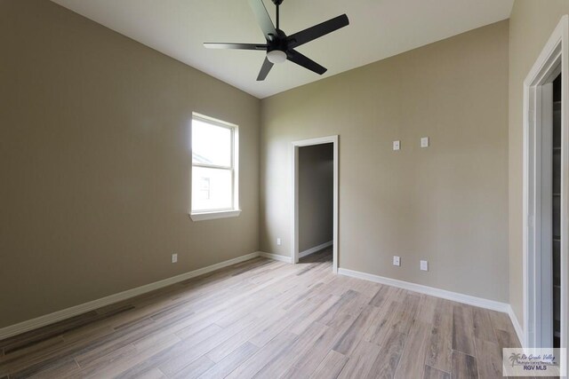 unfurnished bedroom featuring ceiling fan, a spacious closet, and light hardwood / wood-style flooring