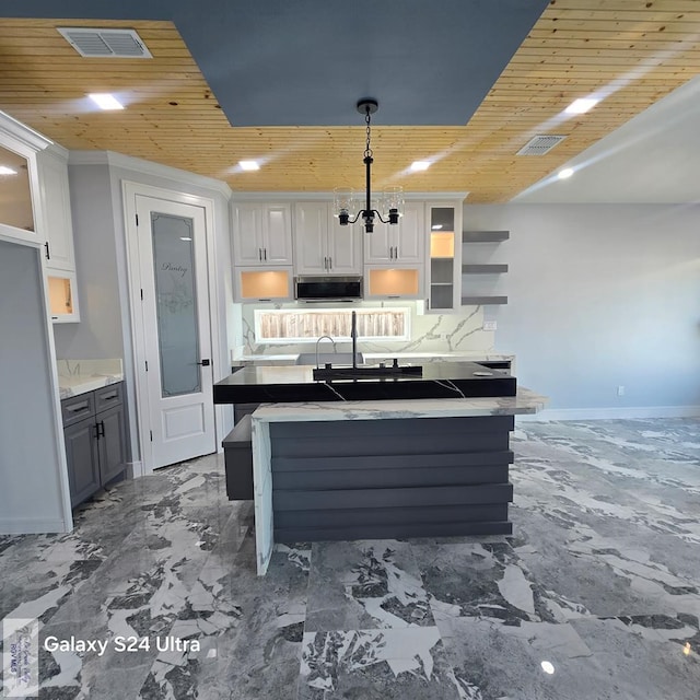 kitchen featuring wood ceiling, stainless steel microwave, white cabinetry, a chandelier, and visible vents