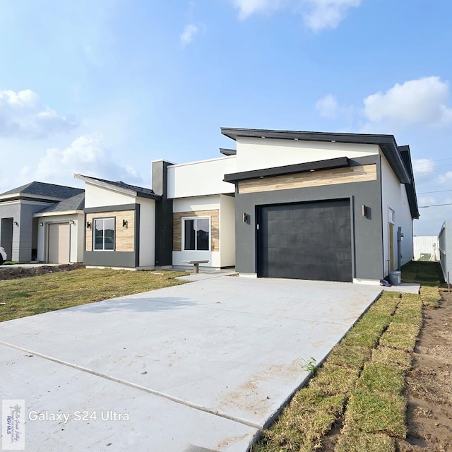 contemporary house with stucco siding, driveway, and an attached garage