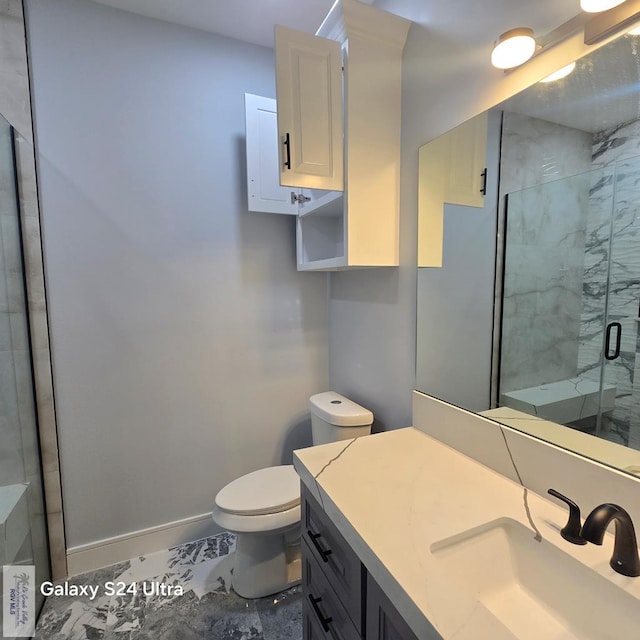 full bathroom featuring a shower stall, vanity, toilet, marble finish floor, and baseboards