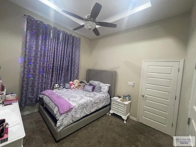 bedroom with baseboards, dark colored carpet, and a ceiling fan