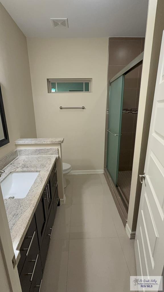 bathroom with a stall shower, visible vents, baseboards, toilet, and vanity