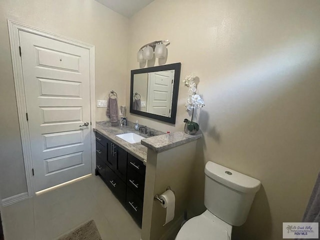 bathroom featuring toilet, tile patterned flooring, and vanity