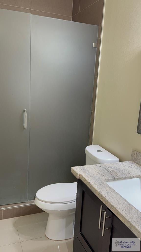 full bathroom with a stall shower, tile patterned flooring, vanity, and toilet