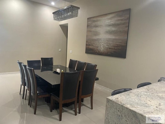 dining space featuring light tile patterned floors and baseboards