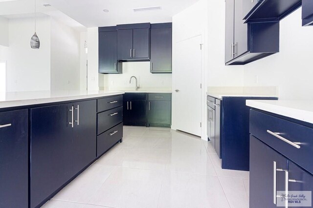 kitchen with ventilation hood, sink, light tile patterned floors, and hanging light fixtures